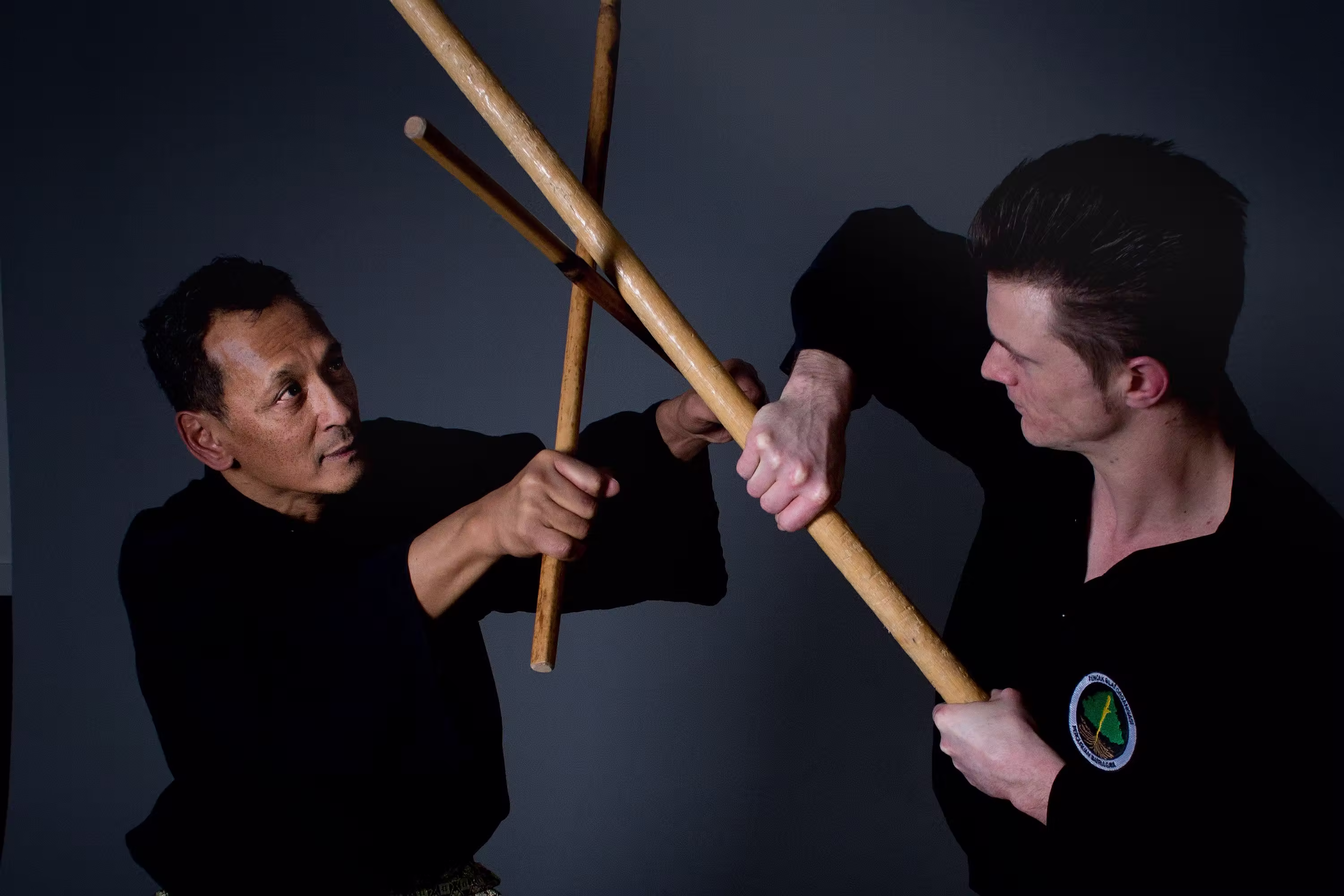 Twee pesilat vechten met een tongkat en toya