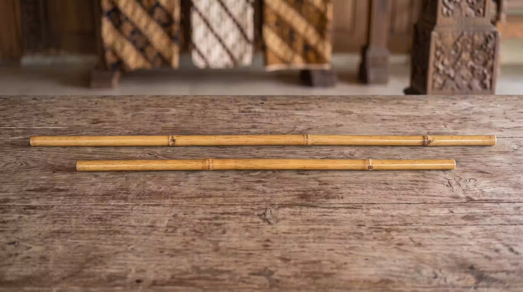 Een tafel met daarop twee tongkat en toya